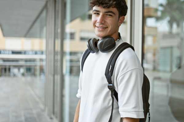 A white male college student with a backpack and headphones. 