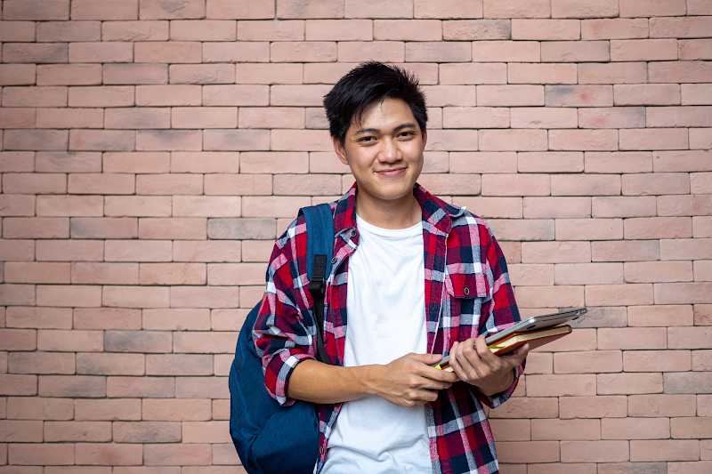 Young man with books and backpack.