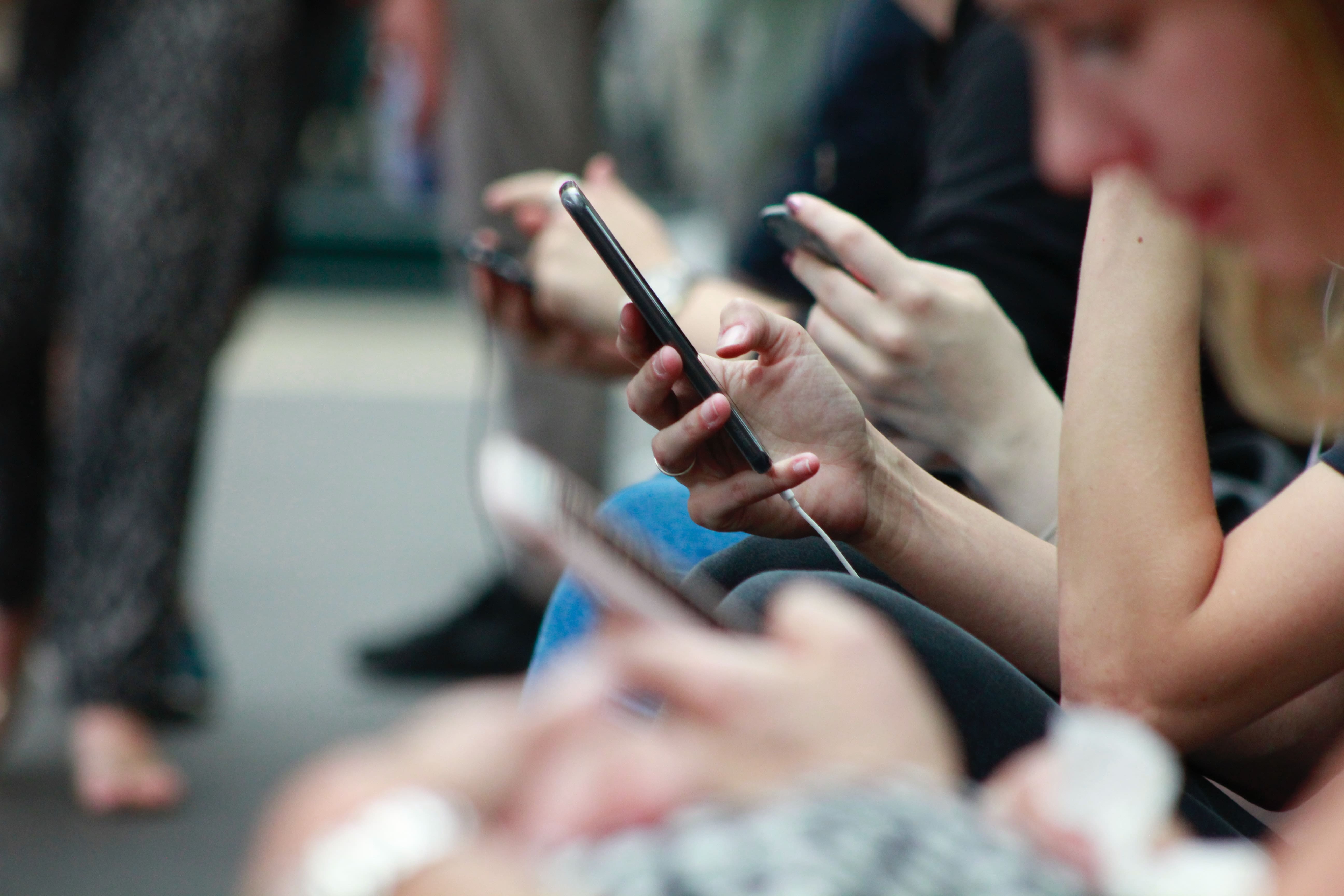 A view of hands holding phones.