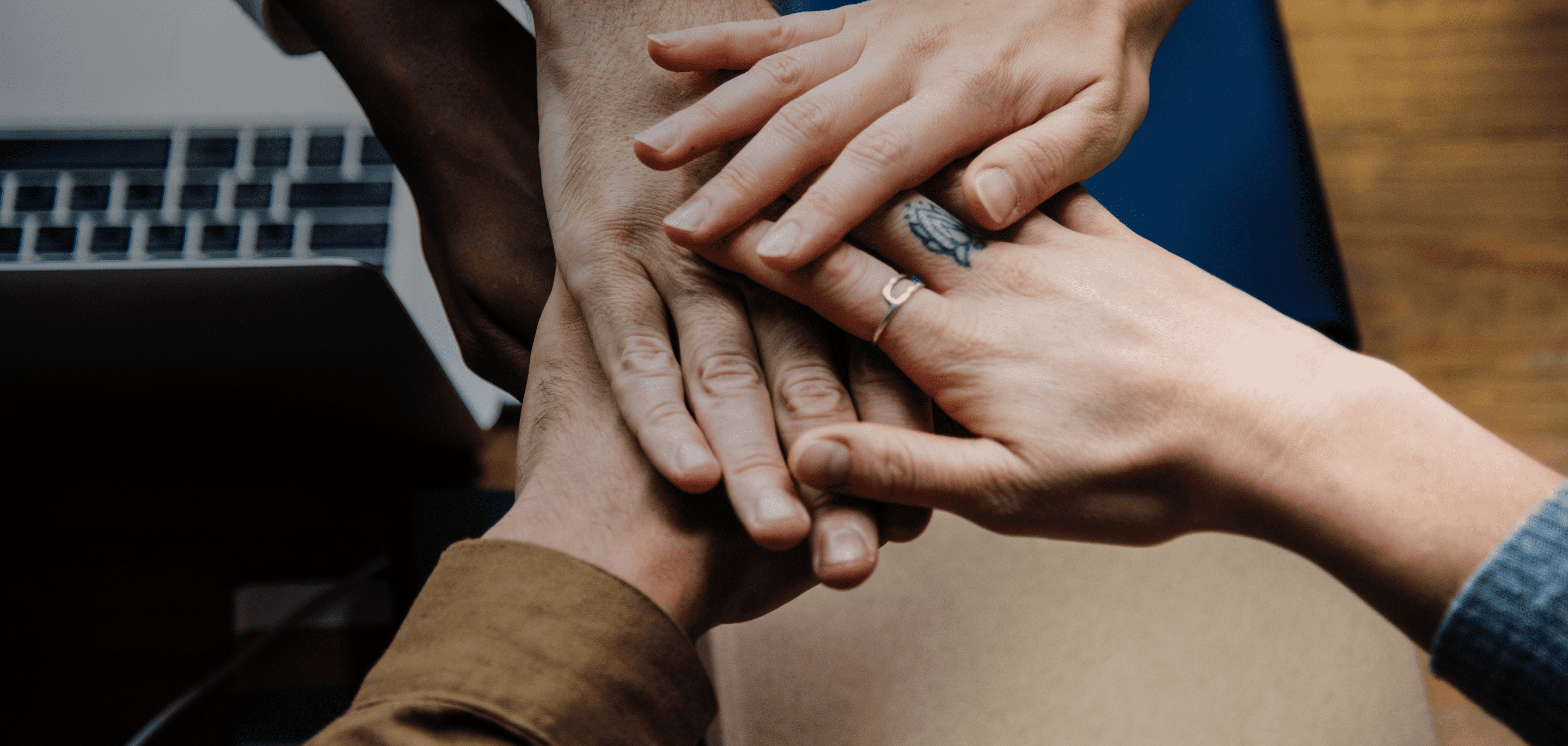 Hands stacked in partnership.