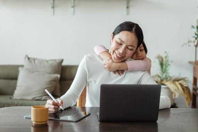 woman on laptop with little girl