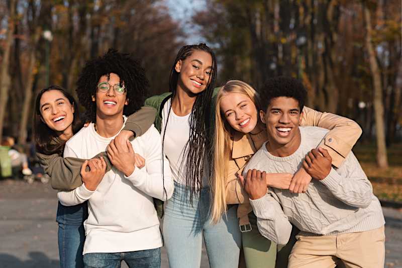 A group of young people are hugging each other. 