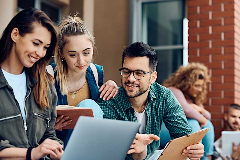 Common App annual report cover page showing a group of students collaborating around a laptop. 