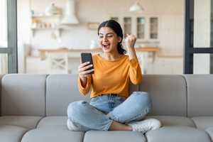 A girl is excitedly looking at her phone.