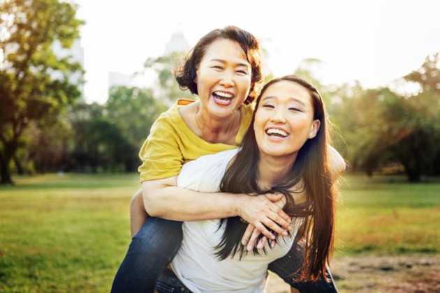 daughter giving mother piggy-back ride