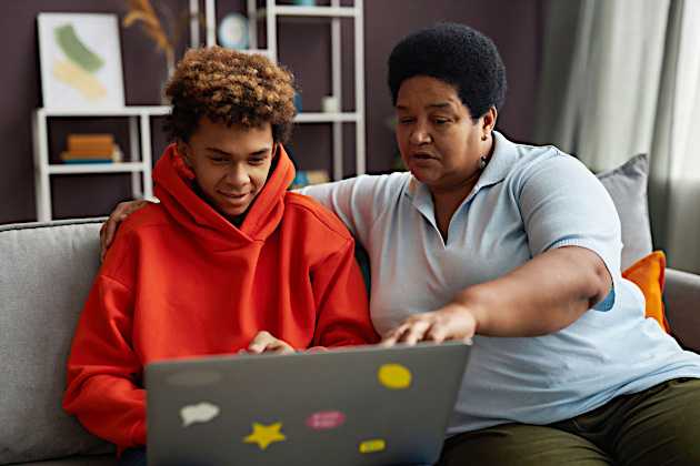 mother and son working together at laptop
